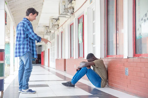 Mobbing-Szene in der Schule. Kaukasischer Teenager macht sich über Afro lustig — Stockfoto