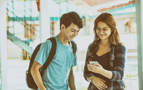 Adolescents camarades de classe souriant dans le hall de l'école à la recherche de smart — Photo