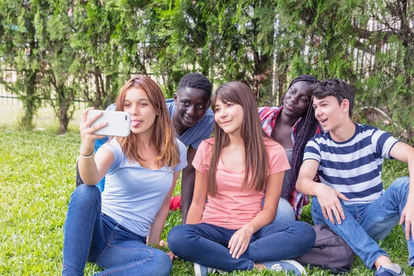 Grupo de raças mistas adolescentes pálido com smarthphone no g — Fotografia de Stock