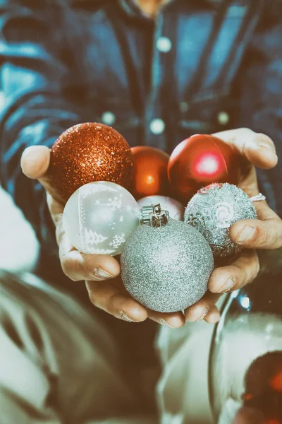 Manos de hombre sosteniendo coloridas bolas de Navidad —  Fotos de Stock
