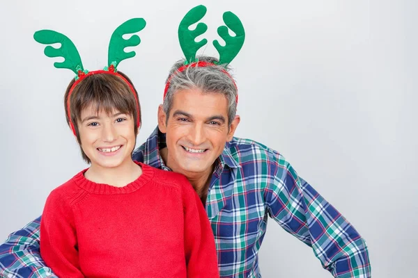 Vater und Sohn scherzen zu Weihnachten zu Hause mit Rentiergeweih — Stockfoto