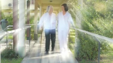 yaşlı bayan hasta parkta yürümeye yardımcı hemşire