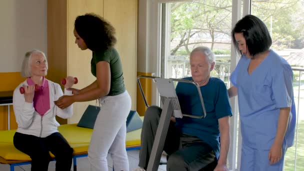 高齢者リハビリ クリニック看護師の助けを借りて 体操を作る — ストック動画