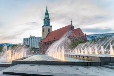 St Mary Kilisesi ve gün batımında, Berlin Alexanderplatz Çeşmesi.