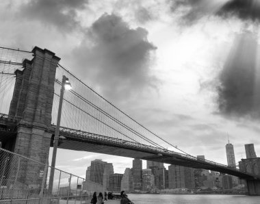 Gün batımında, Brooklyn Köprüsü ve Downtown Manhattan siyah beyaz görünümü.
