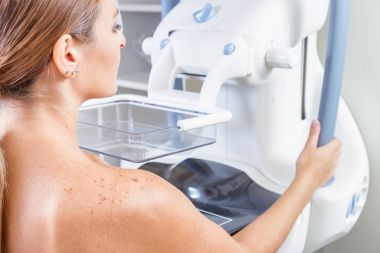 Woman undergoing medical mammography scan. clipart