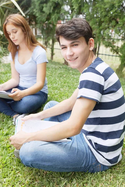 Cuplu Adolescenți Fericiți Aer Liber Făcând Teste Școlare Așezate Iarbă — Fotografie, imagine de stoc