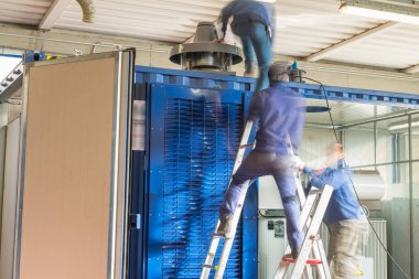 Workders endüstriyel bir tesisi, arkadan görünüm bulanık hareketleri ile.