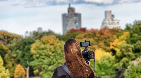 Female photographer taking shots of New York Central Park in aut — Stock Photo, Image