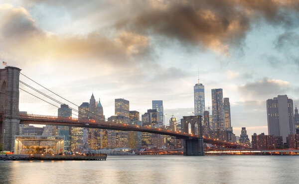 Manhattan skyline and Brooklyn Bridge view from Brooklyn Bridge Park at sunset, New York City.