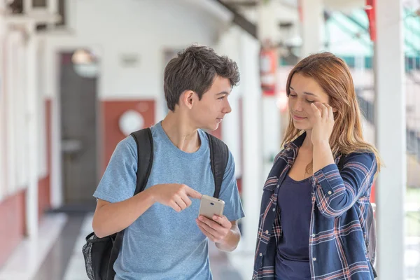Δυο Έφηβοι Μιλούν Για Smartphone Στο Διάδρομο Του Σχολείου — Φωτογραφία Αρχείου
