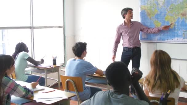 Profesor explicando lección a los alumnos positivos en una t multiétnica — Vídeos de Stock