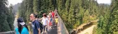 Vancouver, Kanada - 11 Ağustos 2017: Turist Capilano Asma Köprüsü üzerinde. Vancouver alanında büyük bir atttraction olduğunu.
