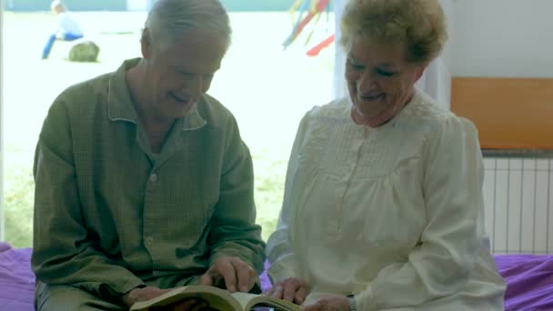 Para Starszy Mężczyzna Kobieta Siedzi Łóżku Razem Czytanie Książki — Wideo stockowe