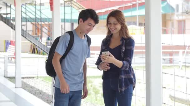 Casal Adolescentes Falando Sobre Smartphone Corredor Escola — Vídeo de Stock