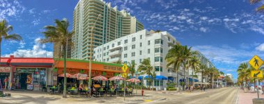 FORT LAUDERDALE, FL - FEBRUARY 29, 2016: Tourists and locals enjoy the promenade along the sea. Fort Lauderdale is a famous tourist attraction in Florida. clipart