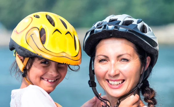 Happy mother and daughter with bike helmet.