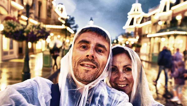 Copule of tourists in the 40s enjoying illuminated street on a r — Stock Photo, Image