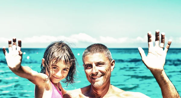 Father and daughtrer waving on the beach — Stock Photo, Image