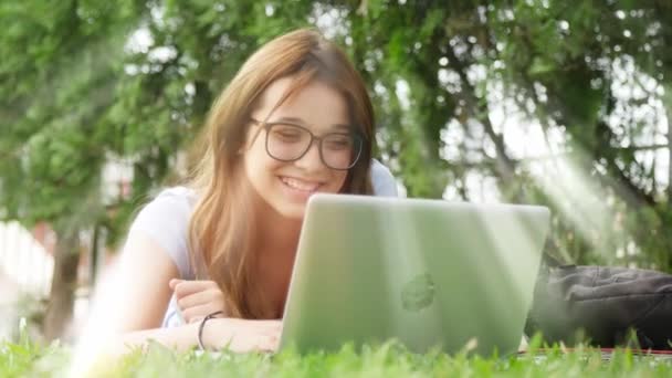 Lachende Tienermeisje Met Behulp Van Tablet Liggen Gras — Stockvideo