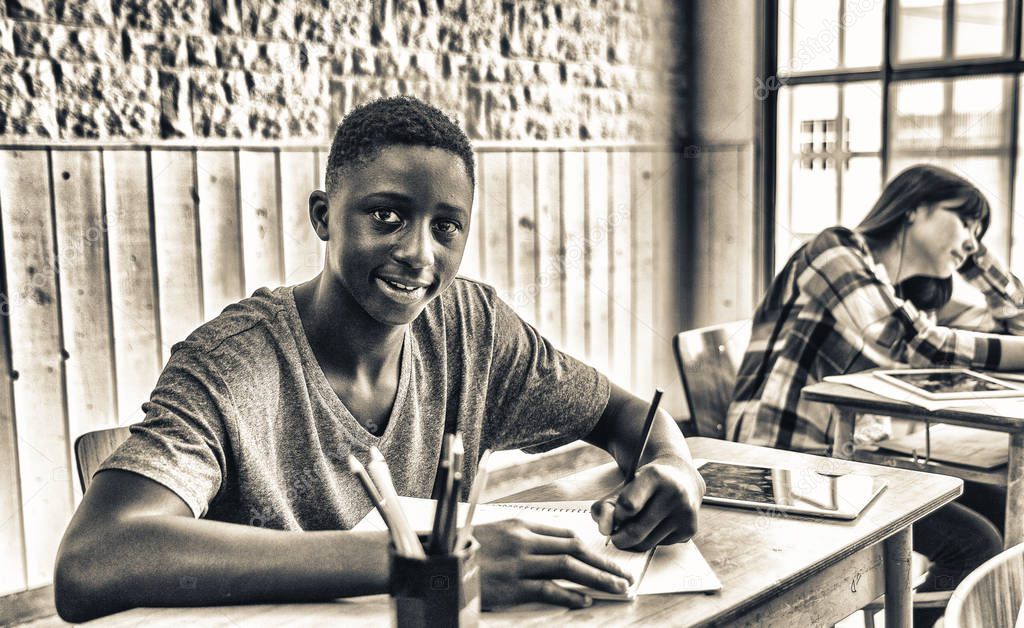 African male teenager making lesson in the classroom and happy about the test.