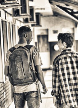 Koridorda yürürken öğrenciler bir çiftin arka görünüm.