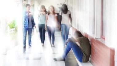 okul koridorda yürüyüş ve katta oturan ve ağlayan bir çocuk zorbalık genç grup