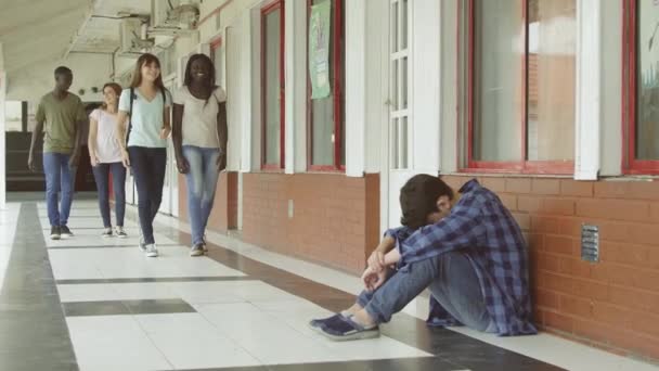 Grupp Tonåringar Går Skolan Hallen Och Mobbning Pojke Som Sitter — Stockvideo