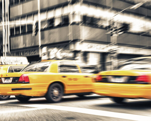 Zoomed and blurred view of New York yellow cabs isolated on black and white background.