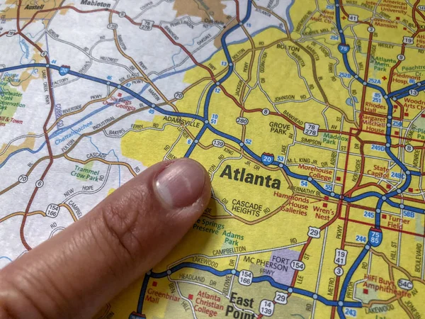 Tourist finger pointing to Atlanta, GA on a atlas map