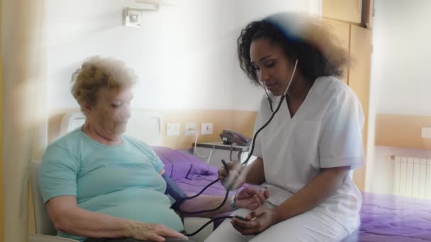 Медсестра Измеряет Артериальное Давление Пожилой Женщине Больнице Здоровье Пенсионное Обеспечение — стоковое видео