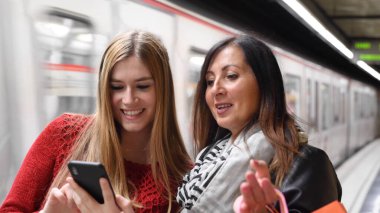 Yazın metro istasyonunda şehre gelen iki kadın..