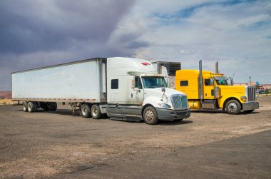 Kırsala park etmiş renkli büyük kamyonlar.