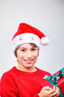Evde Noel şapkalı, beyaz arka planda izole genç bir çocuk..