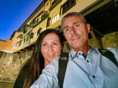 Ponte Vecchio 'nun altında selfie çeken bir çift. Eski Köprü, Floransa.