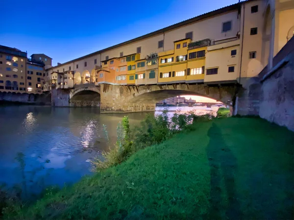 Old Bridge e Florence Lungarni à noite. A paisagem urbana panorâmica i — Fotografia de Stock