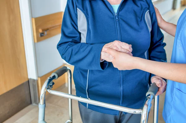 入院中の高齢女性を助ける看護師 — ストック写真