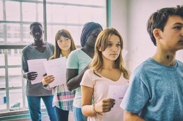 Grupo Adolescentes Multi Étnicos Entregando Teste Escolar — Fotografia de Stock