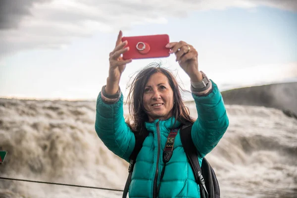 Szczęśliwa kobieta robi selfie z Islandią Wodospady na tle — Zdjęcie stockowe