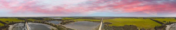 Vista aérea panorámica al atardecer de hermosos pantanos con ro sin pavimentar —  Fotos de Stock