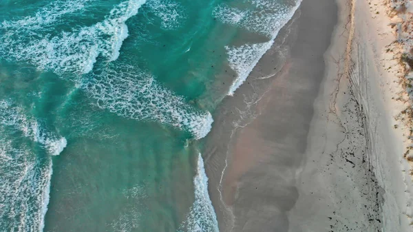 Aerial downward view of waves crushing on a sandy beach — Stock Photo, Image