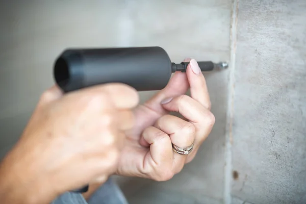 Mujer trabajando en casa con taladro y destornillador — Foto de Stock