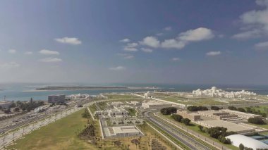 Alacakaranlıkta Abu Dabi hava manzarası. Corniche Yolu ve şehir gökdeleni