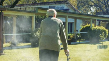 Yaşlı, emekli bir adam ve Walker bahçede geziniyor.