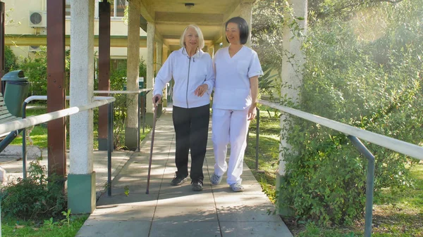 Aziatische Arts Helpt Oudere Gepensioneerde Vrouw Met Wandelstok Het Ziekenhuis — Stockfoto