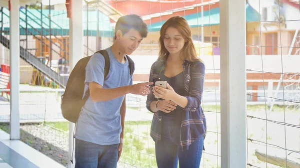 白人青少年情侣在学校里开心地在走廊里聊天 — 图库照片