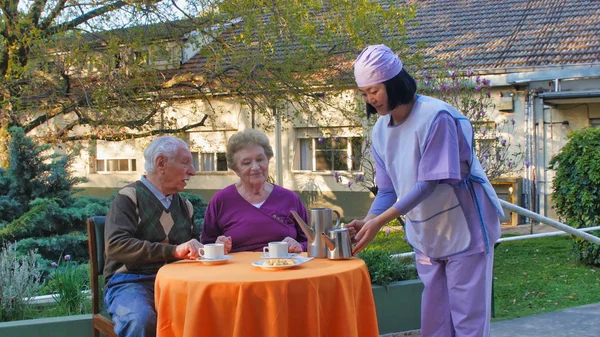 Genç Asyalı Garson Yaşlı Çiftlere Hastane Rehabilitasyon Merkezinde Kahvaltı Servisi — Stok fotoğraf