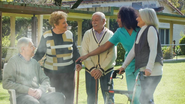 Afrikaanse Verpleegster Praat Met Twee Oudere Gepensioneerde Stellen Buiten Afkickkliniek — Stockfoto