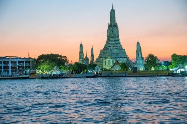 Wat Arun ve turuncu gün batımı gökyüzü arka planda Chao Phraya R