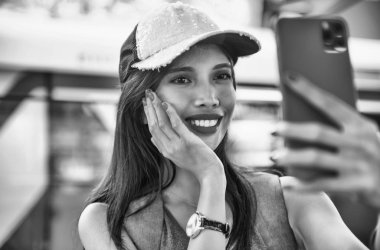 Şapka takıp selfie çeken Asyalı güzel bir kadın.